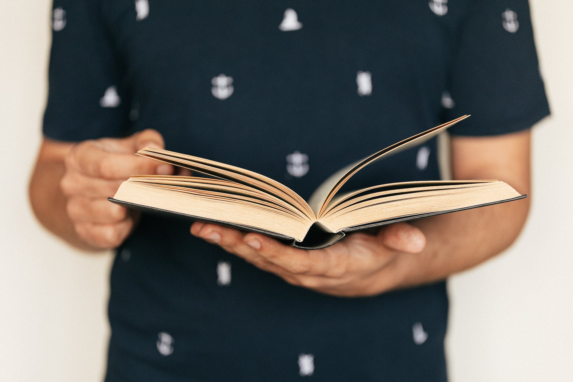 faceless man in tee shirt paging interesting book